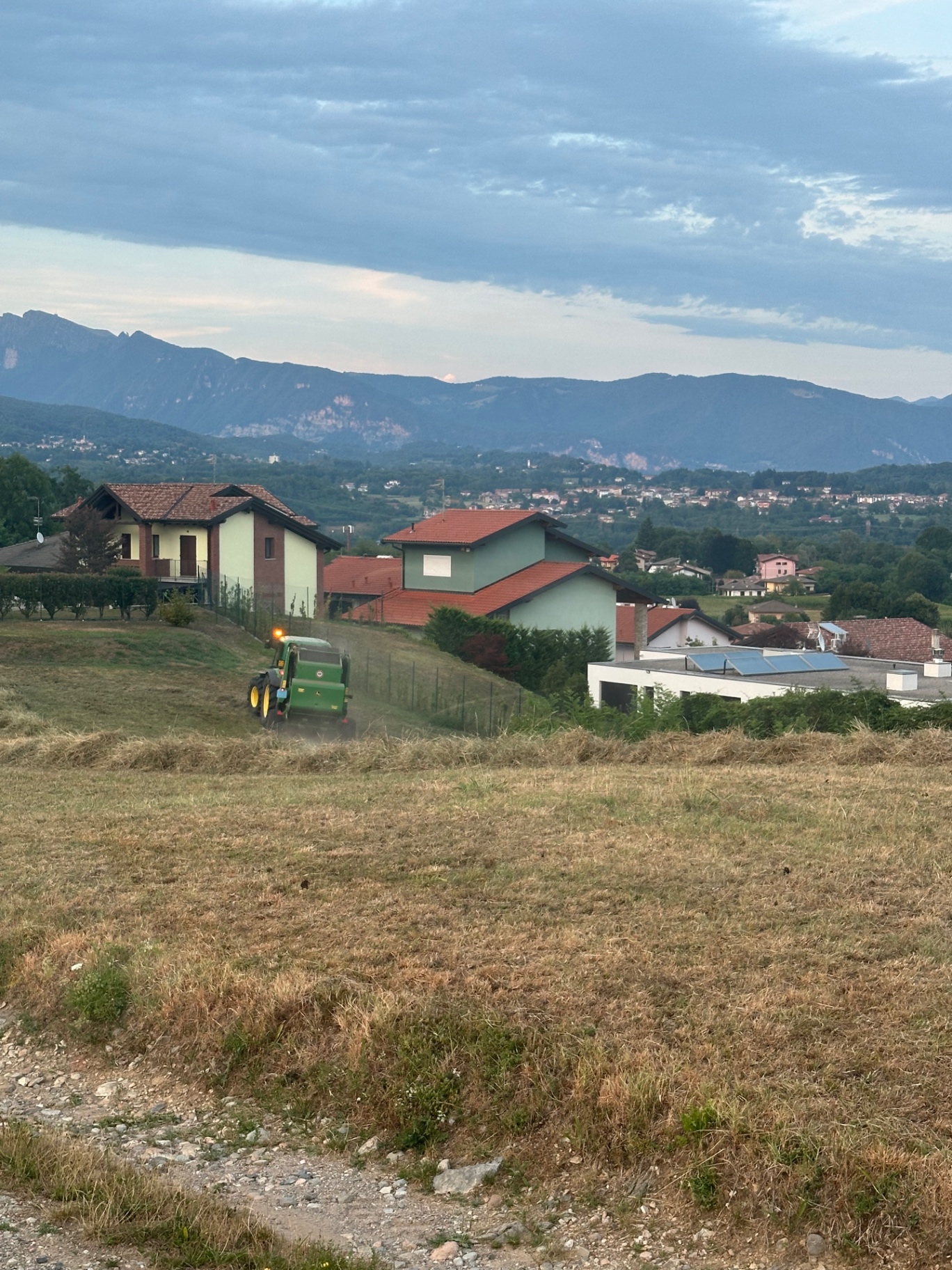 La ballatura del fieno la sera con le montagne sullo sfondo