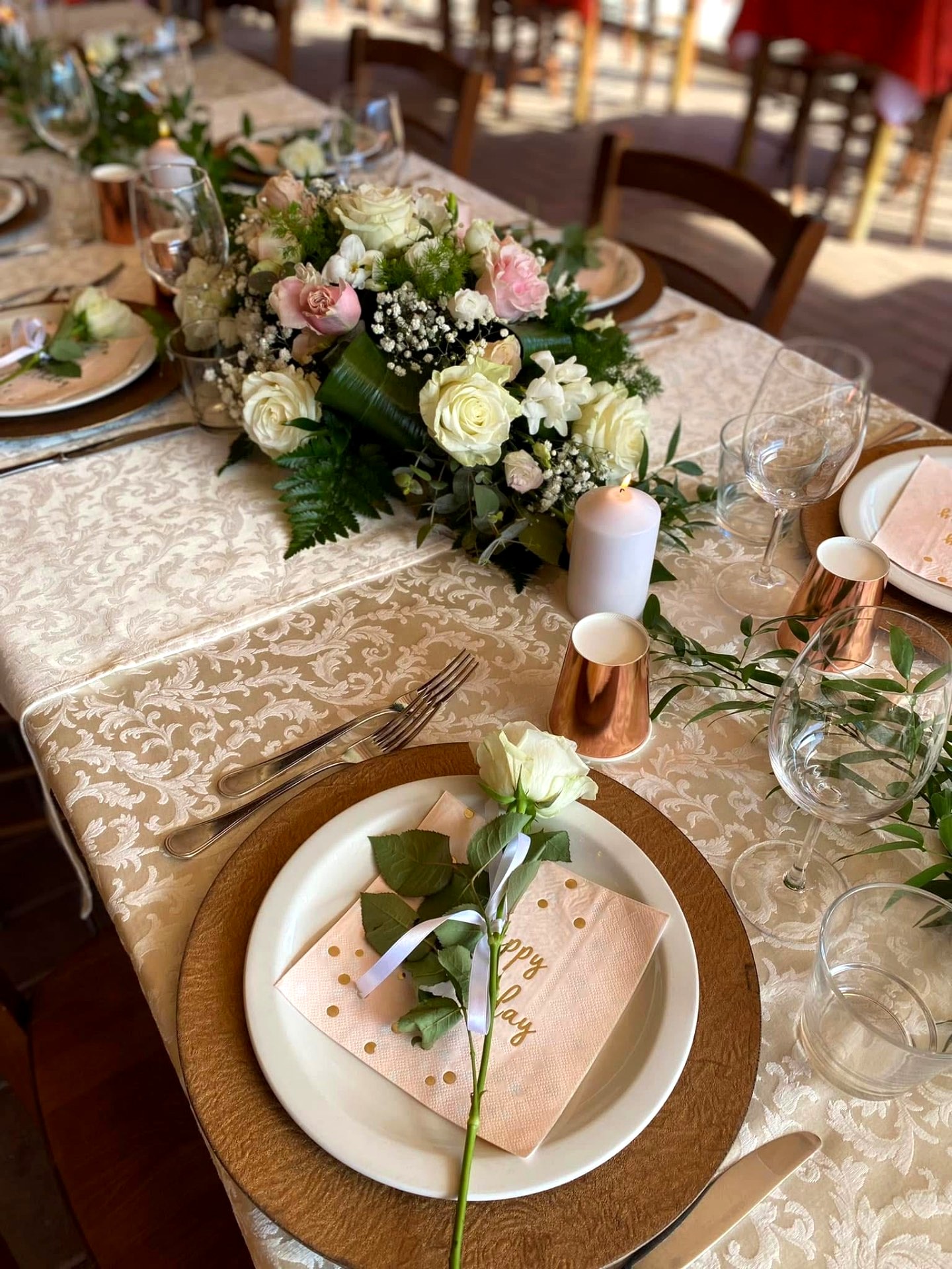 Tavola apparecchiata con rosa e segnaposto