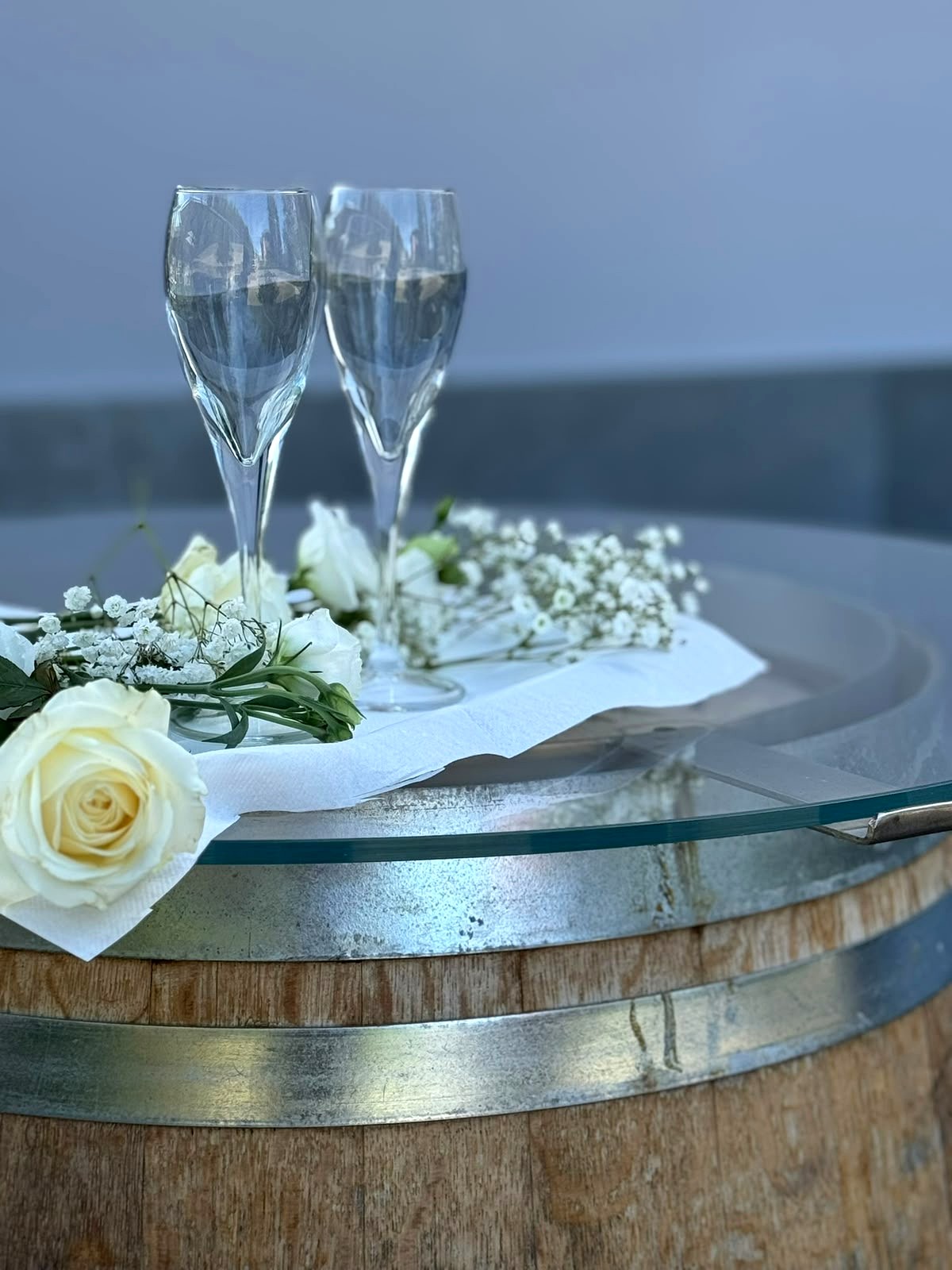 Calici degli sposi sulla botte con rose bianche
