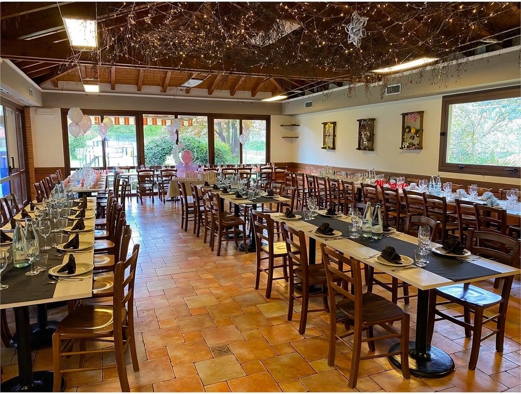 La sala interna addobbata per una festa, con rami e lucine a soffitto